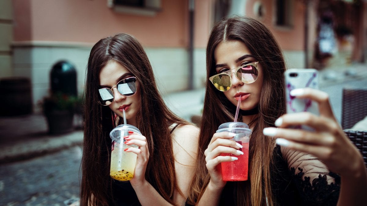 Two young women pose for selfies